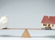 piggy bank and house on a tetter totter